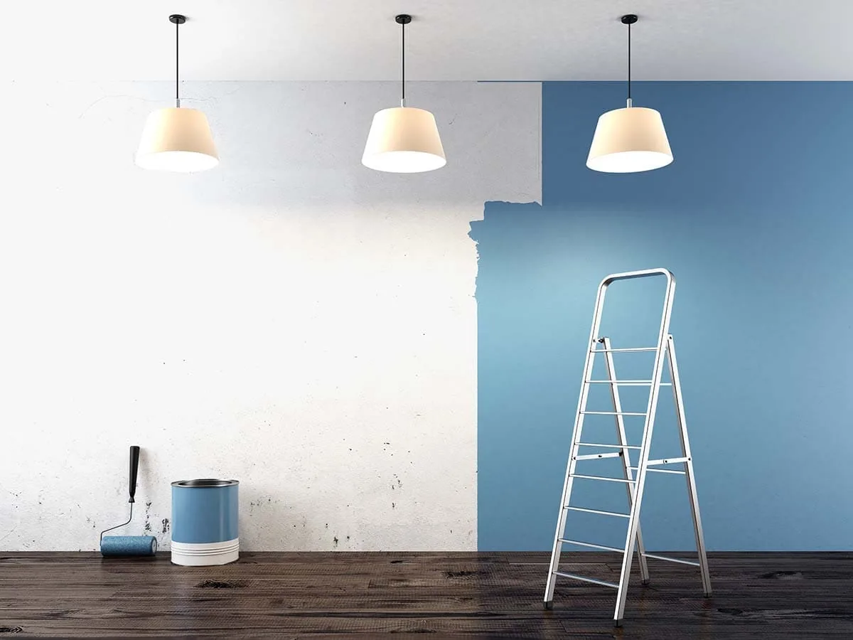 Pared a medio pintar con escalera, rodillo y bote de pintura en una vivienda de Las Palmas