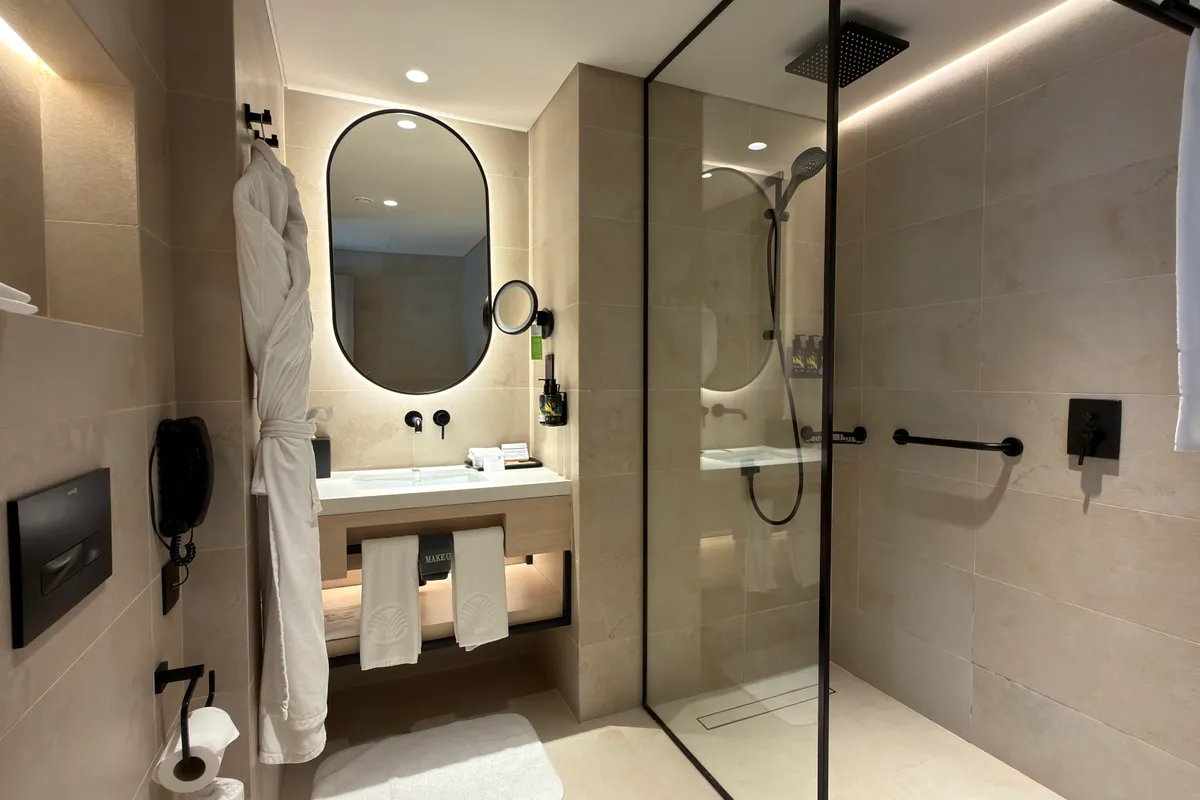 Baño de hotel con ducha de diseño y grifería actual