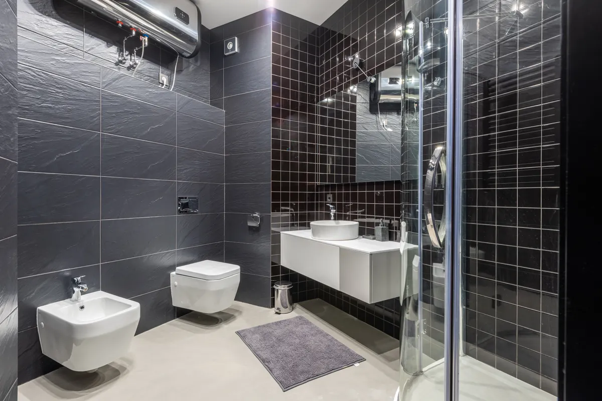 Baño moderno con ducha y bidé revestido de azulejo negro