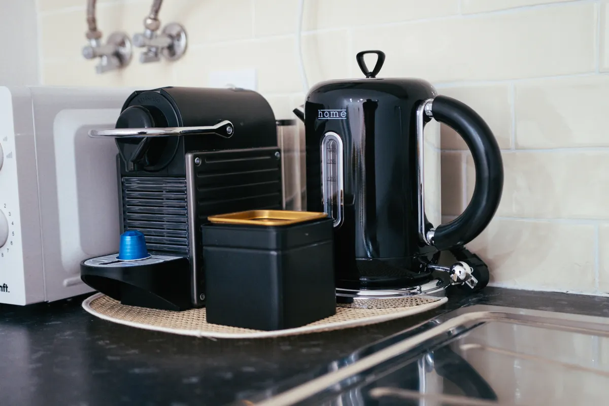 Cafetera y hervidor negros sobre la encimera de una cocina moderna