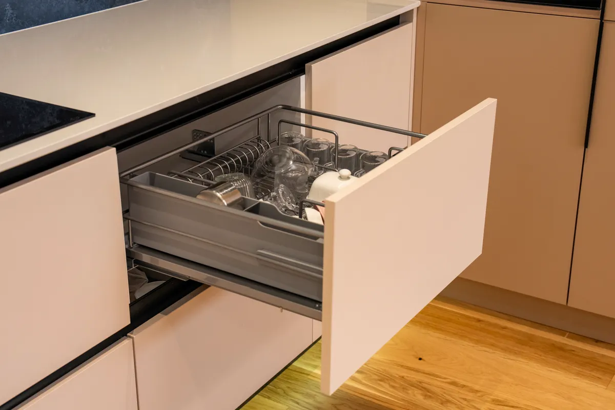 Cajón de cocina abierto con la cristalería y los cubiertos bien ordenados