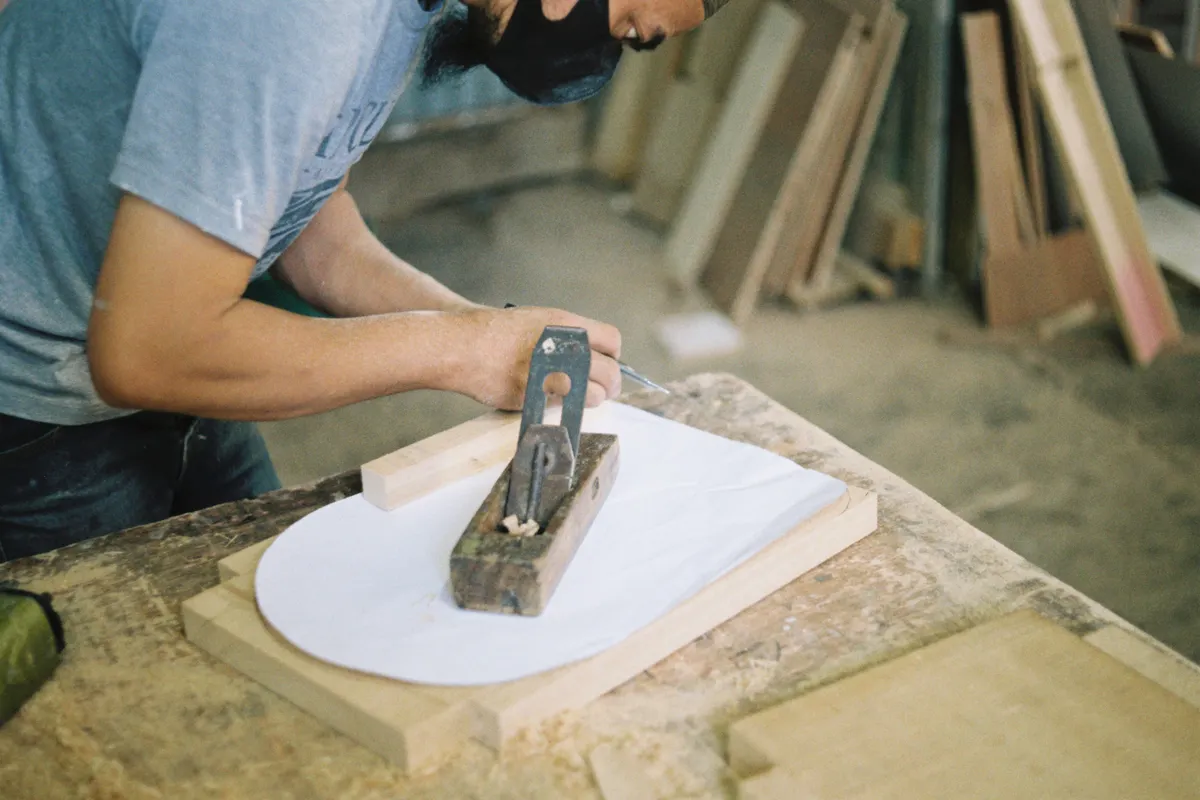 Carpintero trabajando la madera con un cepillo manual