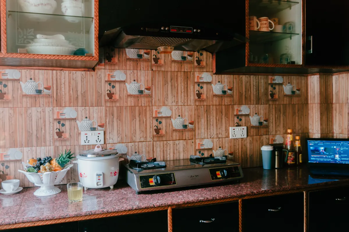 Cocina acogedora con arrocera, fogones, decoración rústica de madera y armarios acristalados