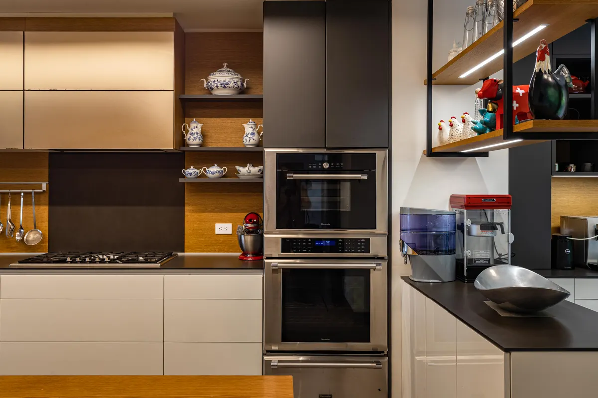 Cocina contemporánea con muebles de líneas limpias, dos hornos y decoración elegante