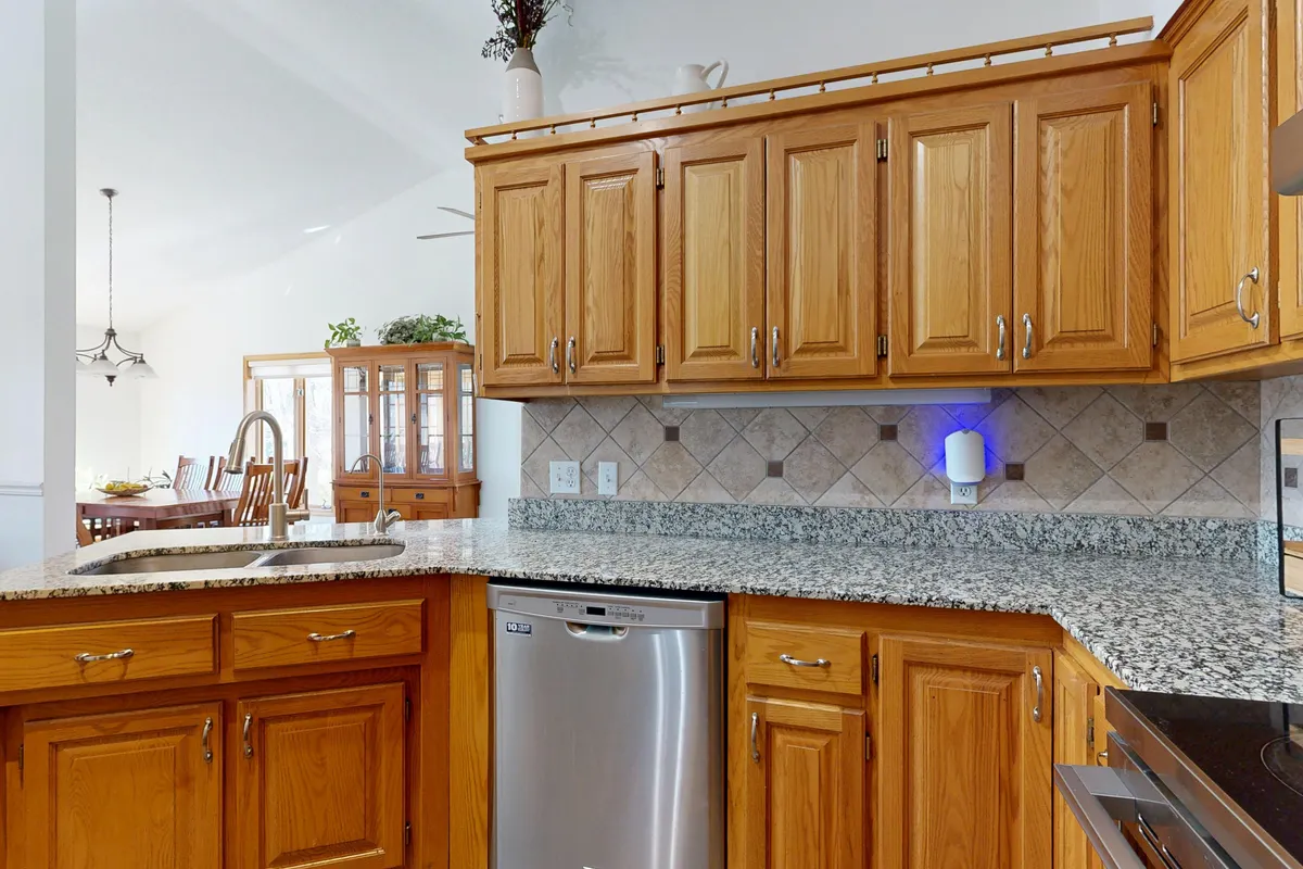 Cocina moderna y luminosa con muebles de madera y encimeras de granito