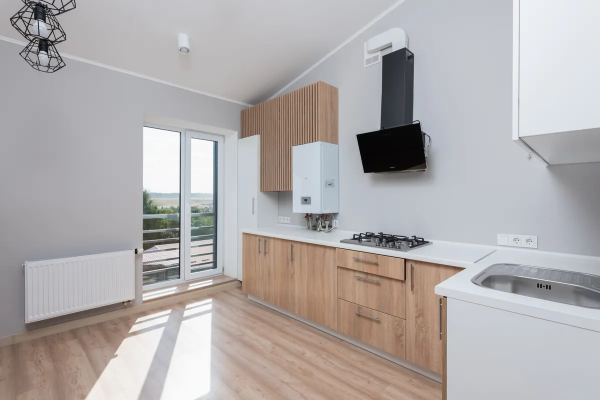 Cocina vacía con muebles de madera y grandes ventanales