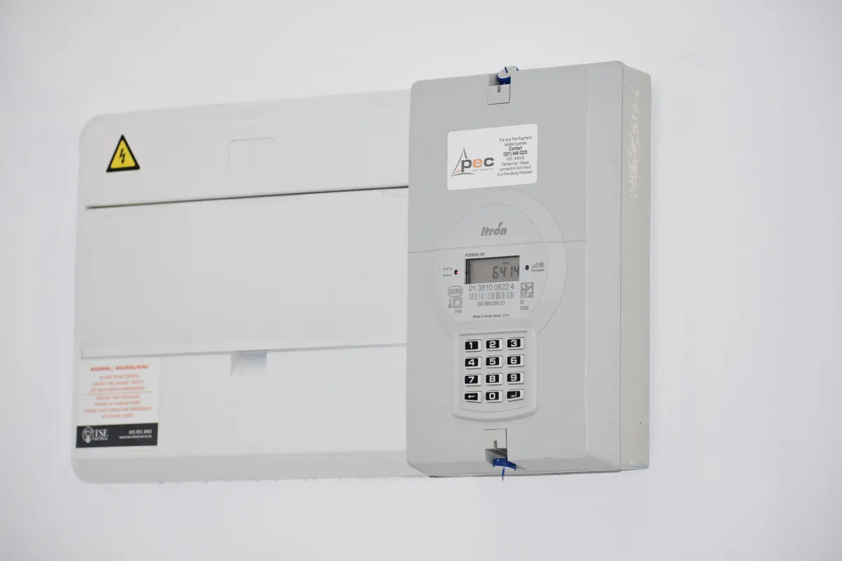 Contador eléctrico y caja de fusibles en una pared blanca