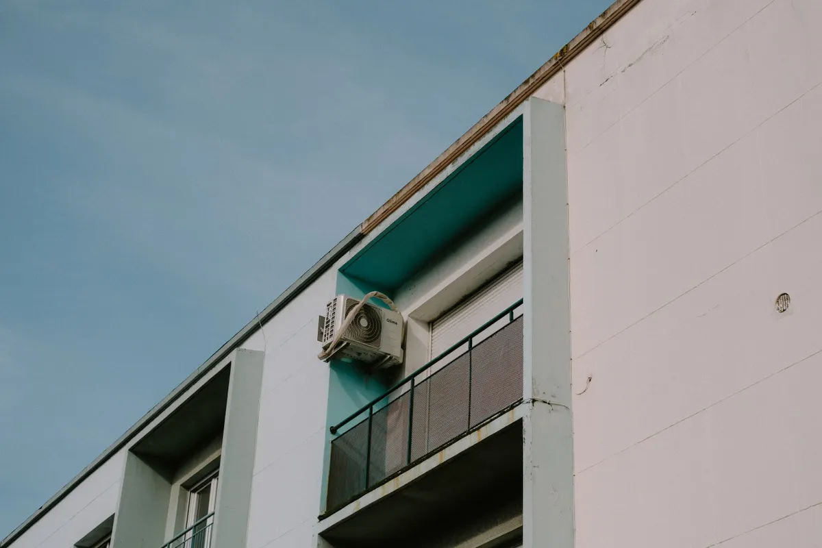 Contrapicado de un bloque de pisos moderno con un balcón y una unidad de aire acondicionado