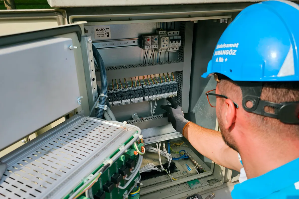 Electricista trabajando en una caja de fusibles situada en el exterior