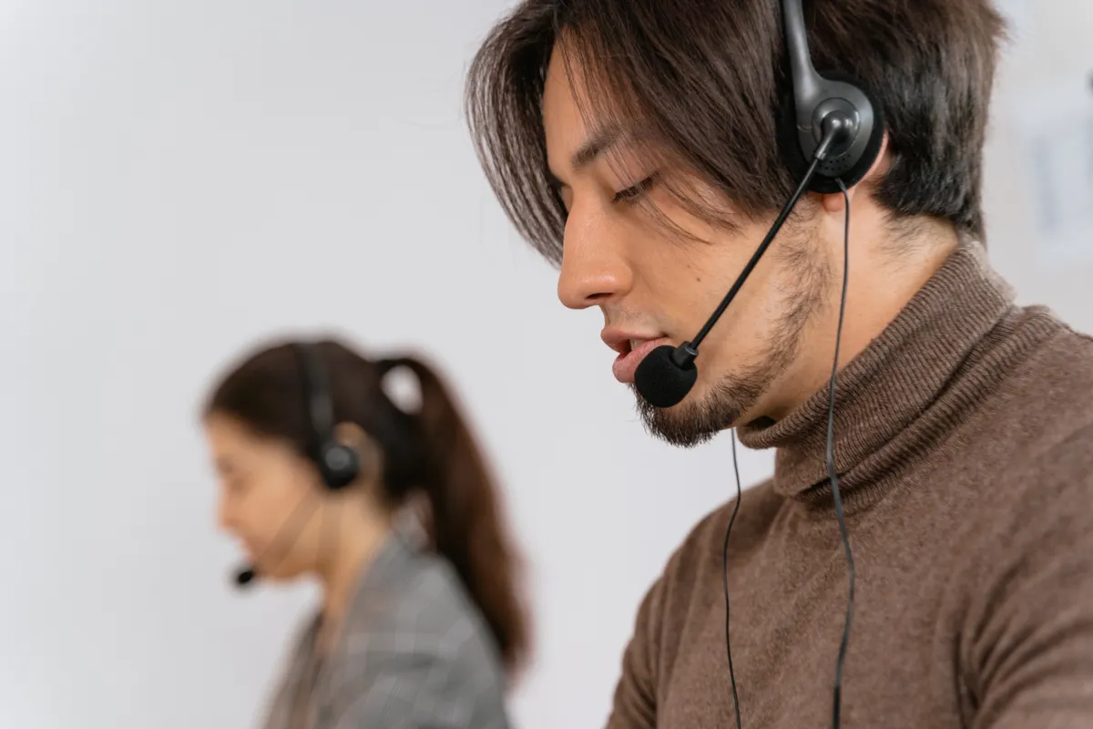 Empleados concentrados de un centro de llamadas atendiendo a clientes con auriculares