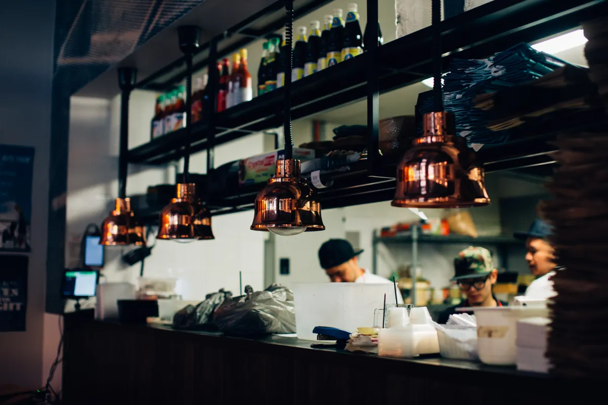 Equipo trabajando en la cocina de un restaurante bajo luz cálida