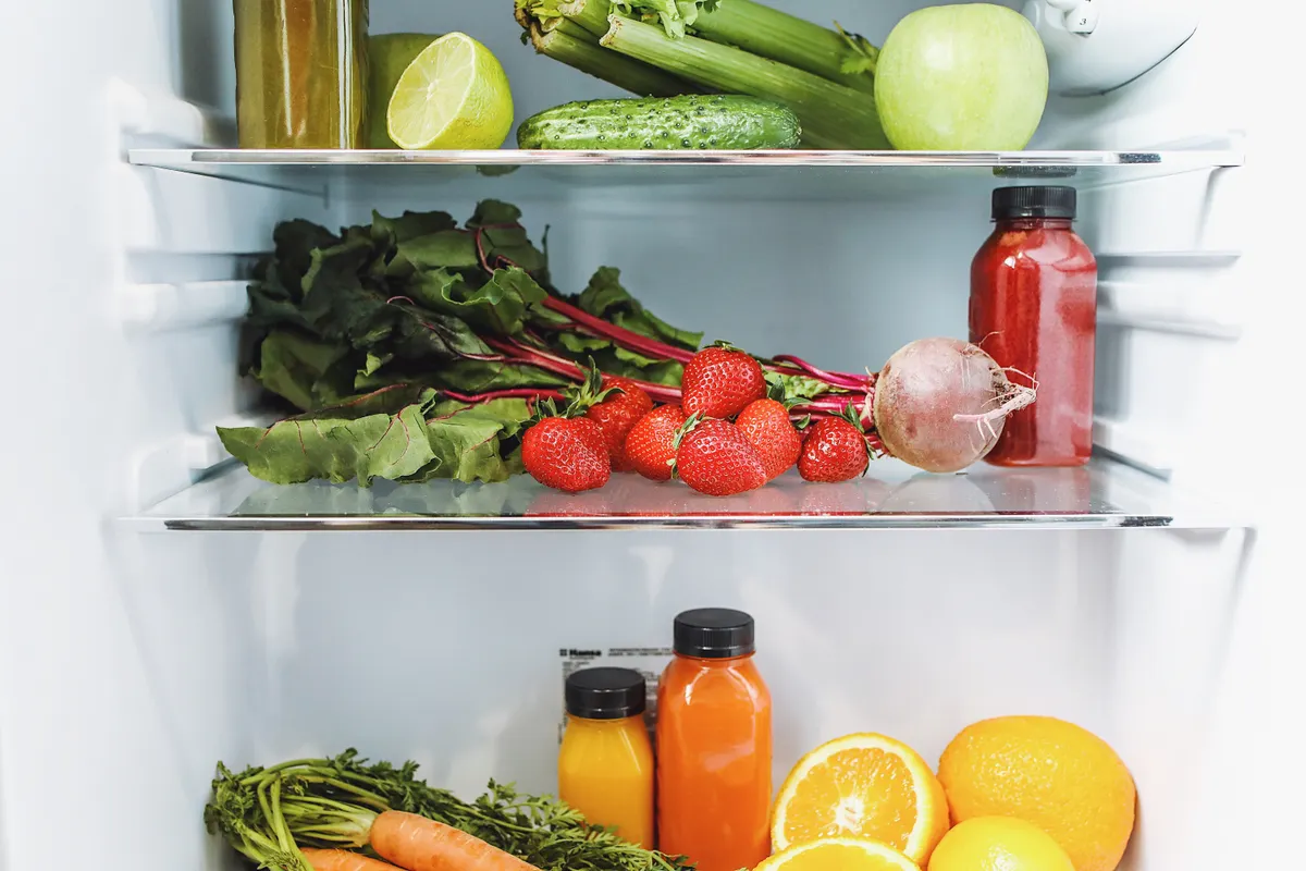 Frutas y verduras de colores ordenadas en un frigorífico abierto