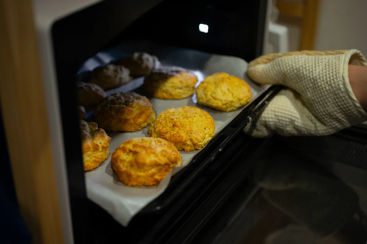 Galletas recién hechas sacadas del horno con una manopla
