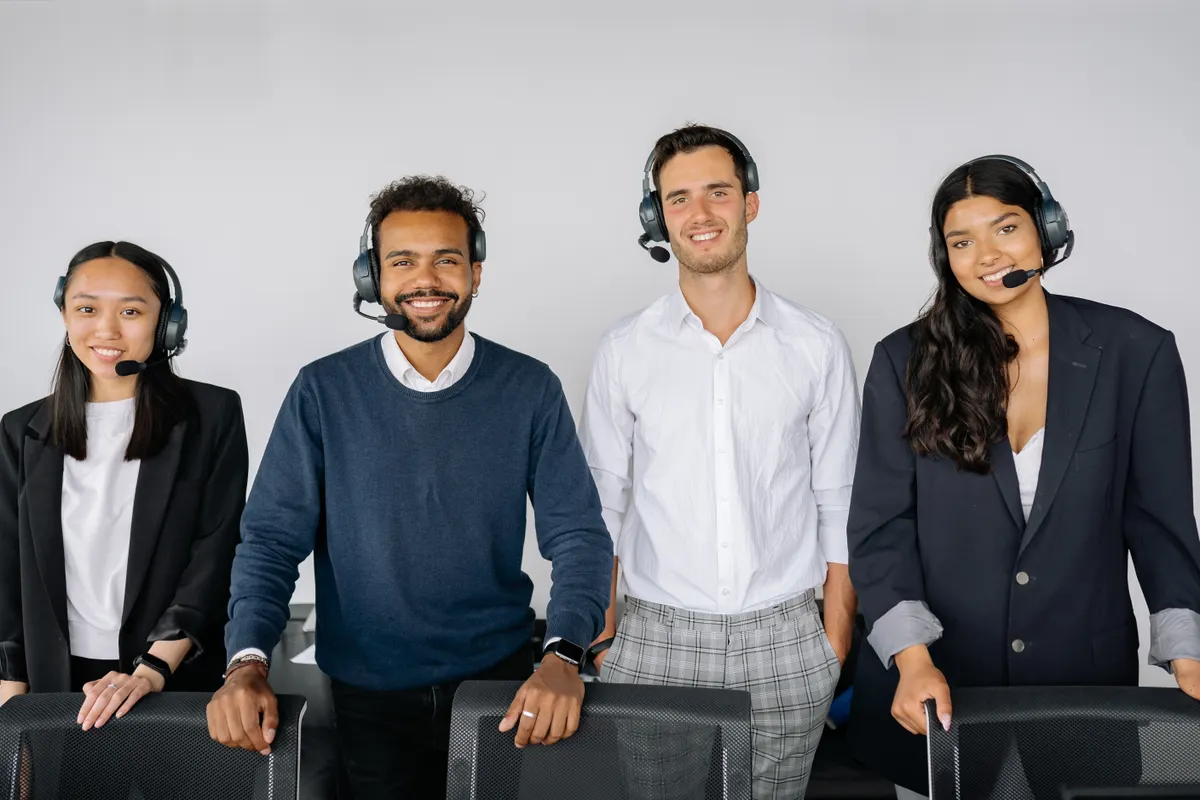 Grupo diverso de agentes de atención al cliente con auriculares en una oficina moderna