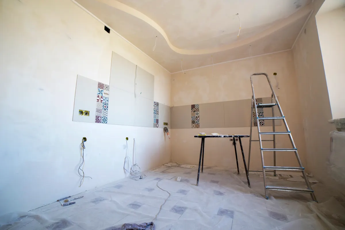 Habitación en reforma con pintura, azulejos y herramientas
