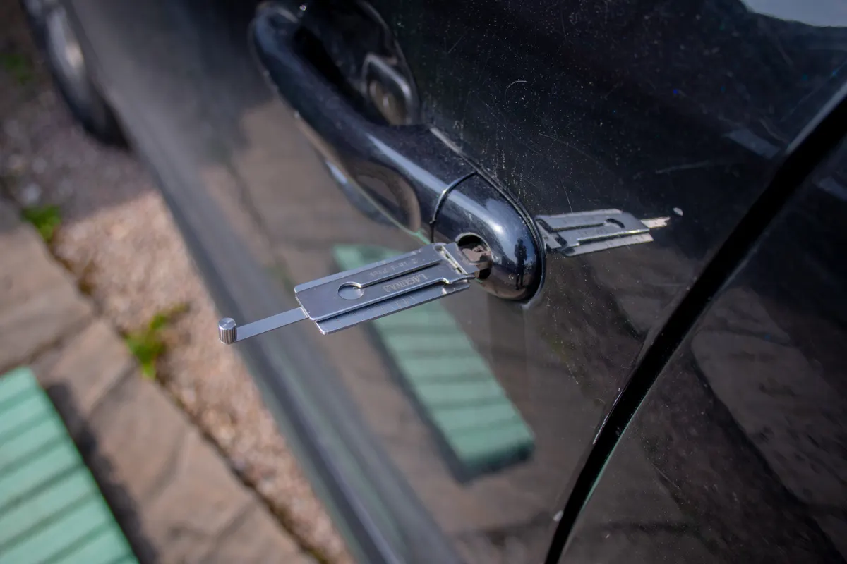 Herramienta de cerrajería introducida en la cerradura de la puerta de un coche