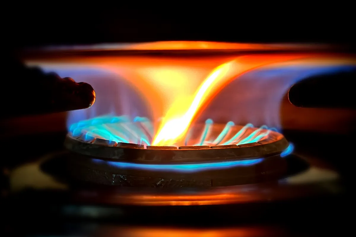 Llamas azules y anaranjadas en el quemador de una cocina de gas