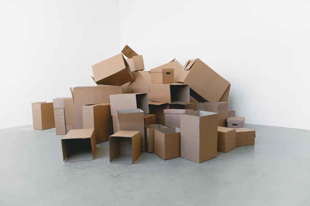 Montón de cajas de cartón preparadas para la mudanza en el suelo de una casa