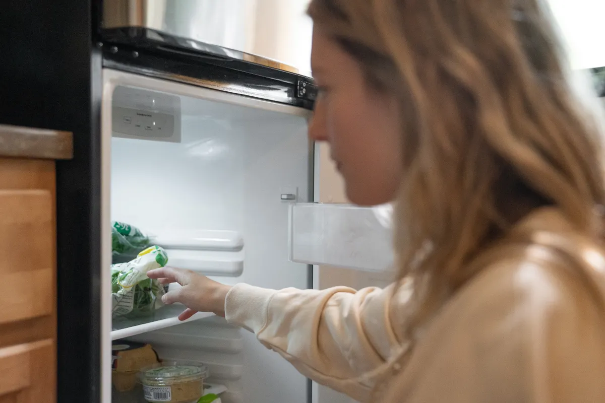 Mujer sacando unas verduras del interior del frigorífico