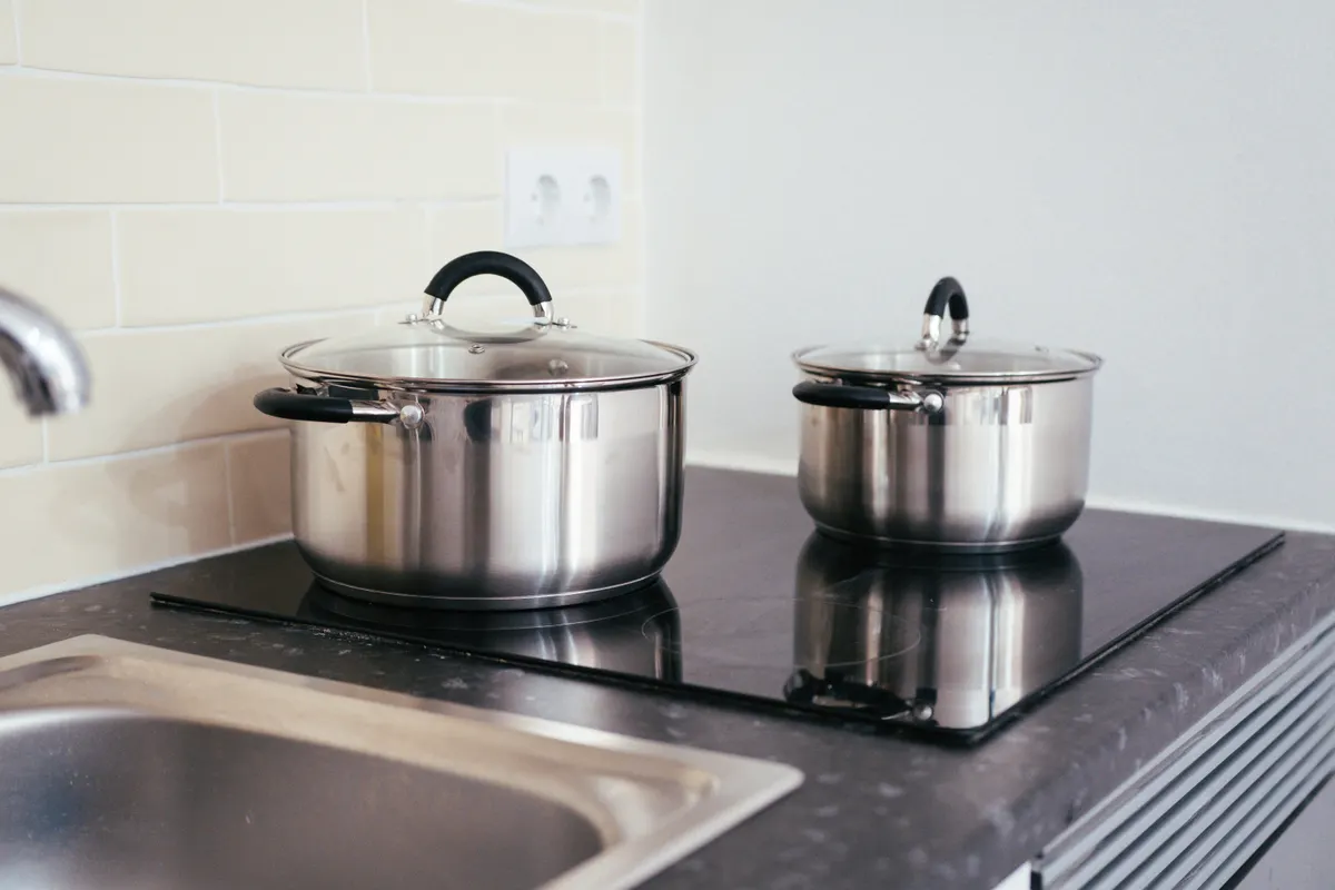 Ollas de acero inoxidable sobre una placa de inducción en una cocina actual