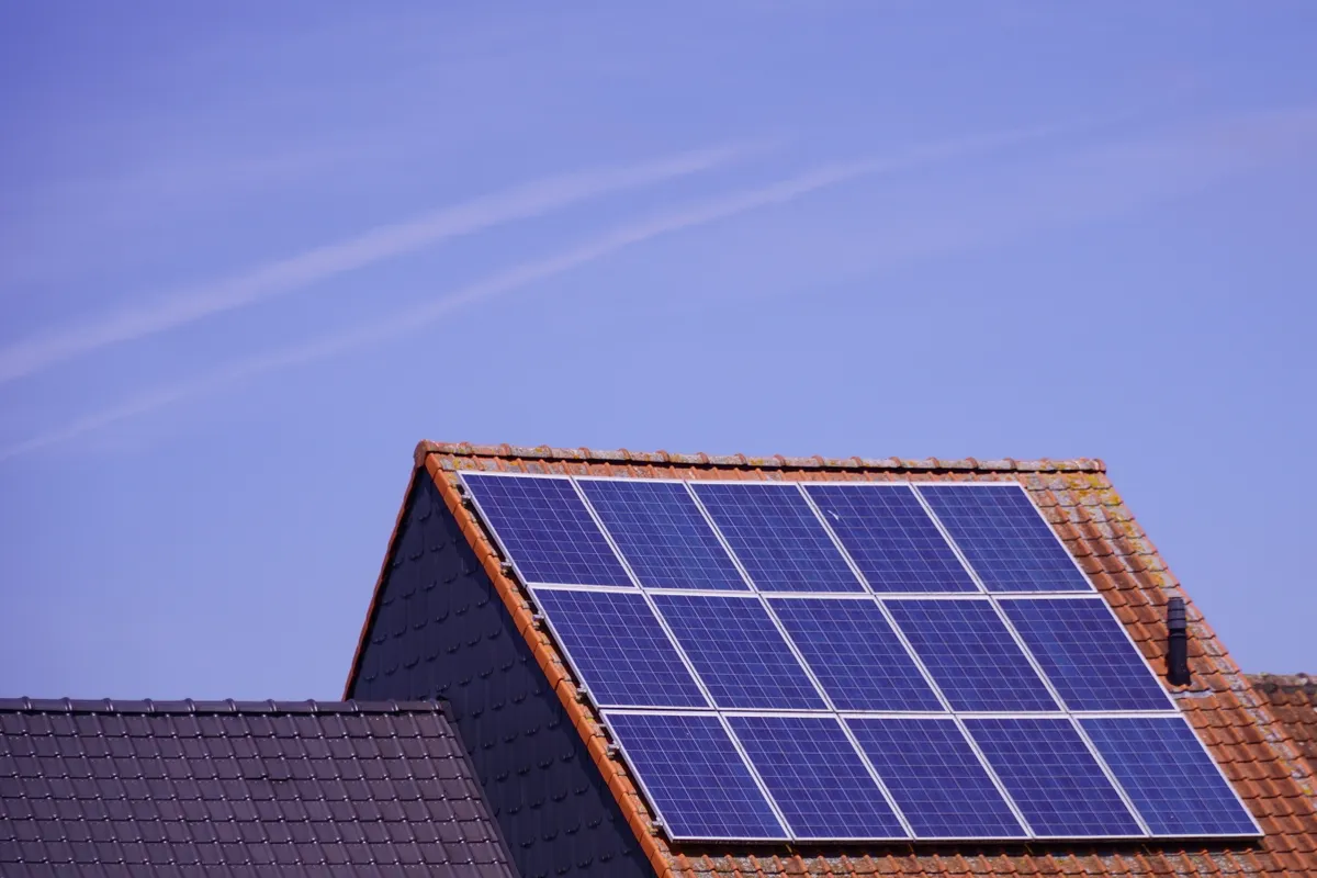 Paneles solares en un tejado de tejas bajo un cielo despejado