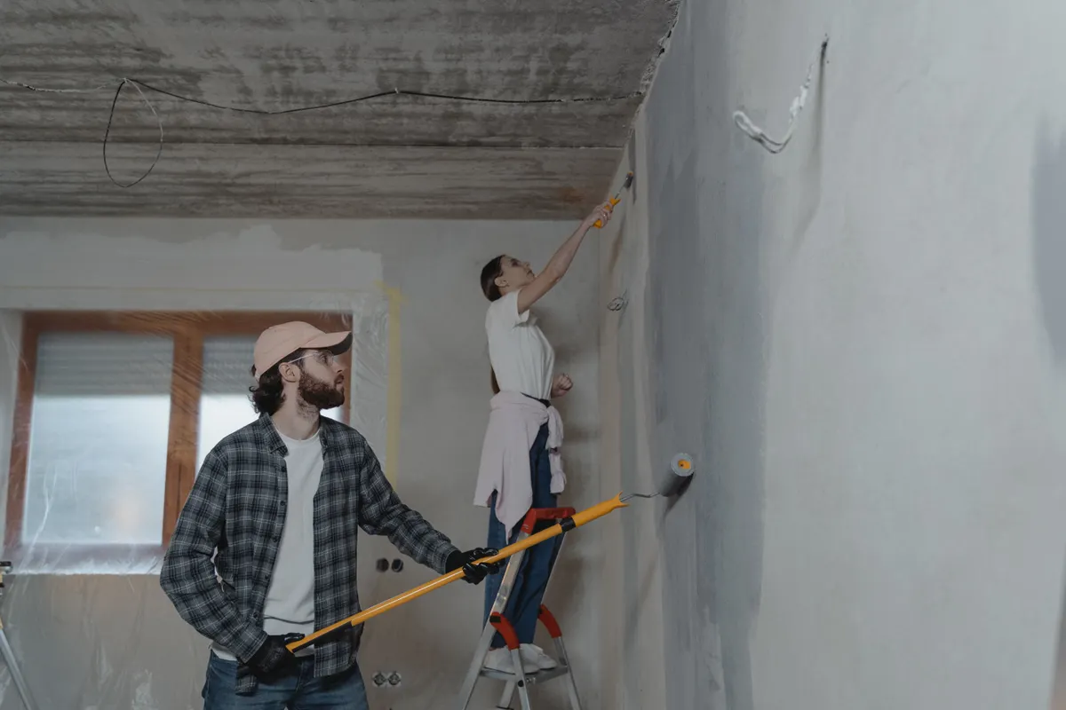 Pareja pintando una habitación en equipo durante una reforma del hogar