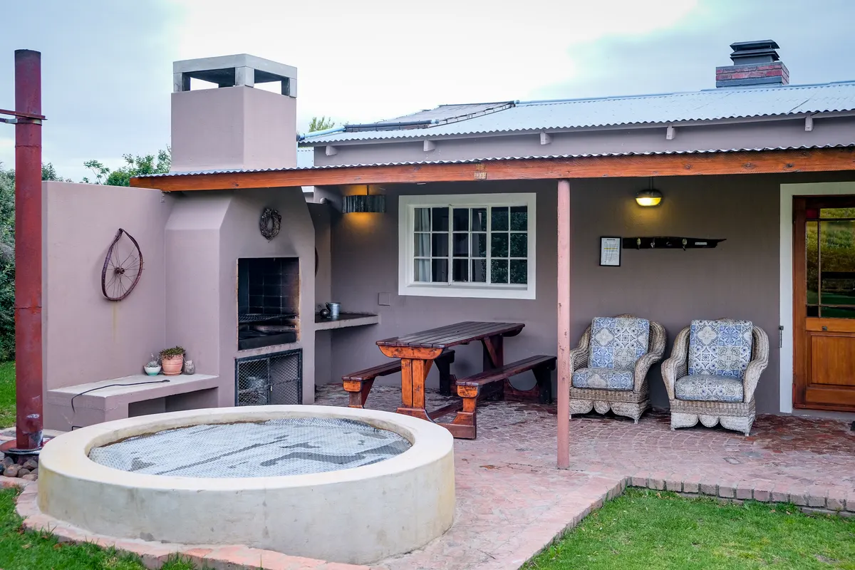 Patio de una vivienda con jacuzzi y una zona de asientos cómodos