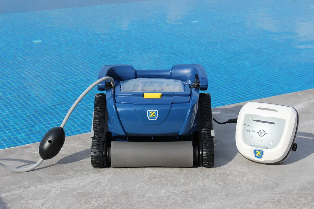 Robot limpiafondos colocado en el borde de una piscina