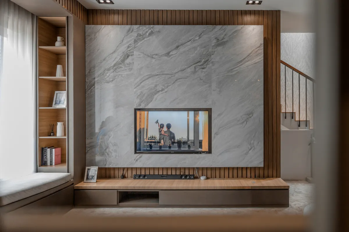 Salón acogedor con chimenea de piedra, televisor y decoración contemporánea
