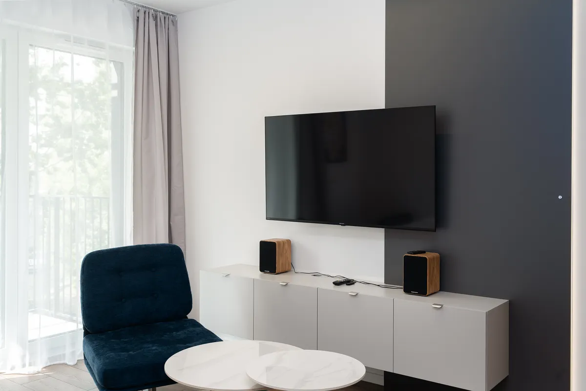Salón contemporáneo con un televisor fino colgado en la pared y decoración cuidada