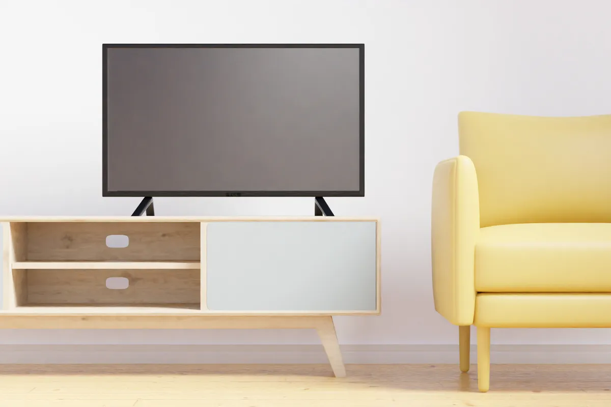 Salón minimalista con televisor de pantalla plana, butaca amarilla y muebles de madera