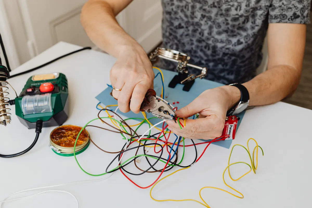 Técnico cortando y ordenando cables de colores con unos alicates
