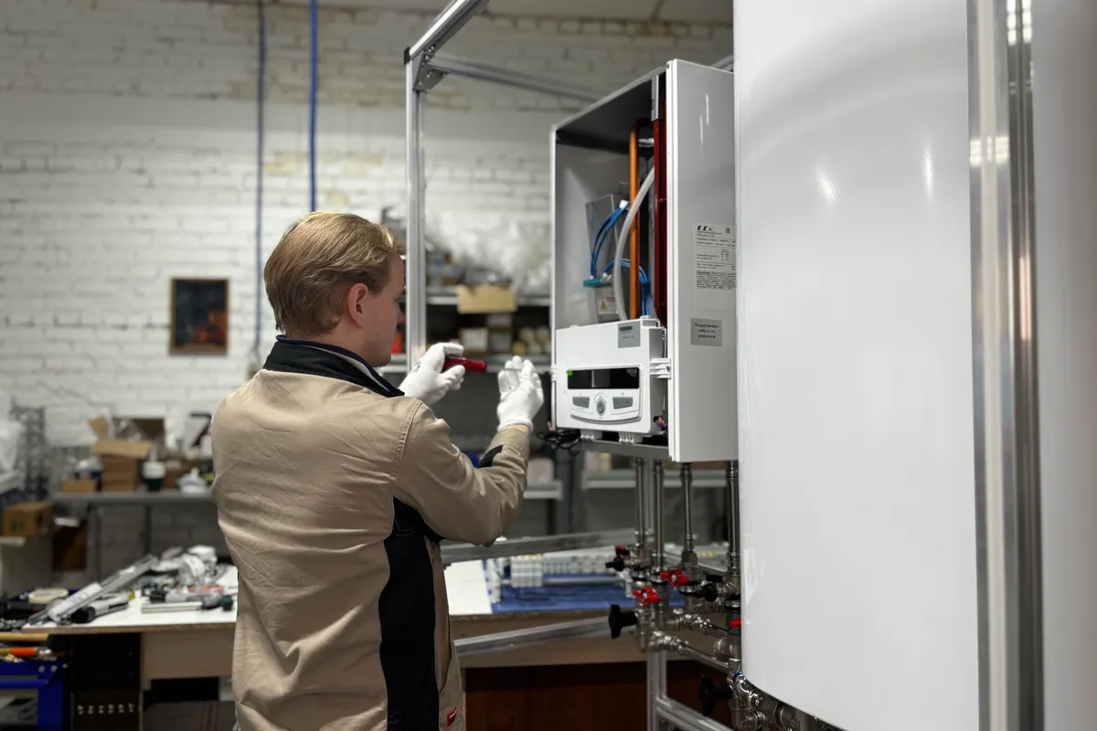 Técnico revisando y reparando un sistema de calefacción en un taller