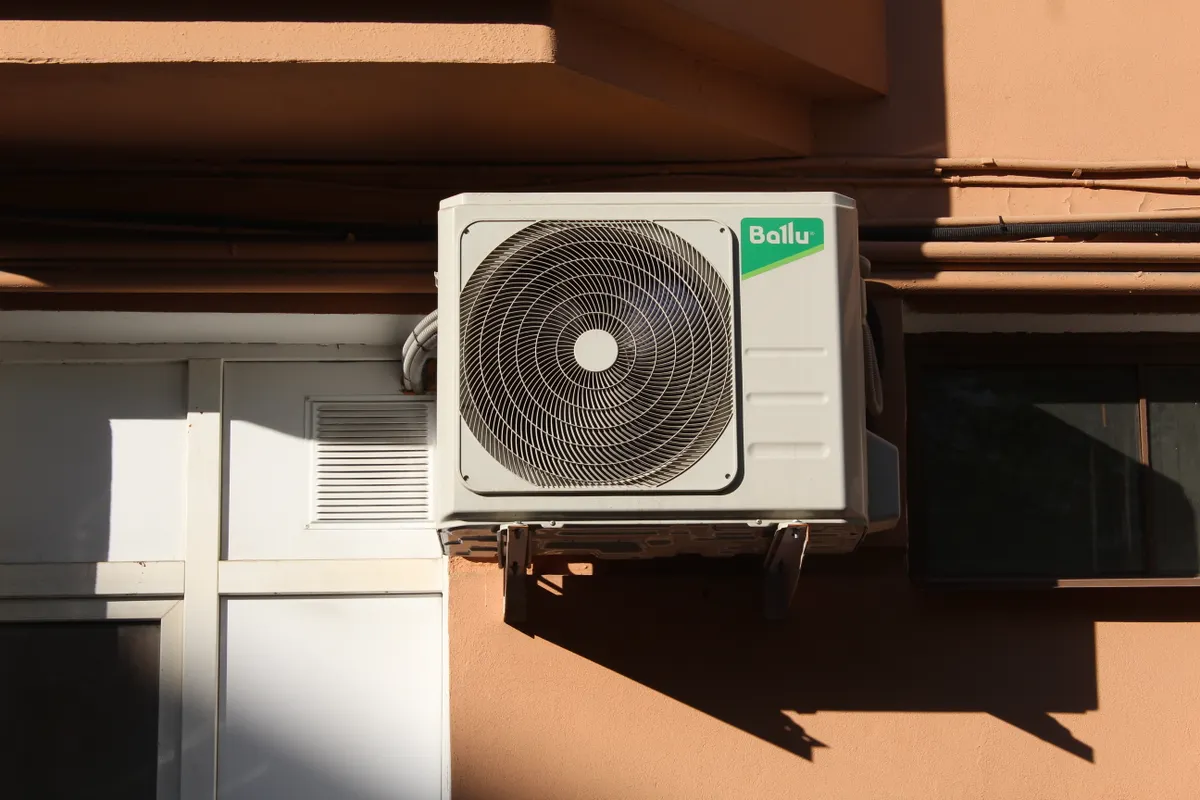 Unidad condensadora de aire acondicionado instalada en el exterior de un edificio