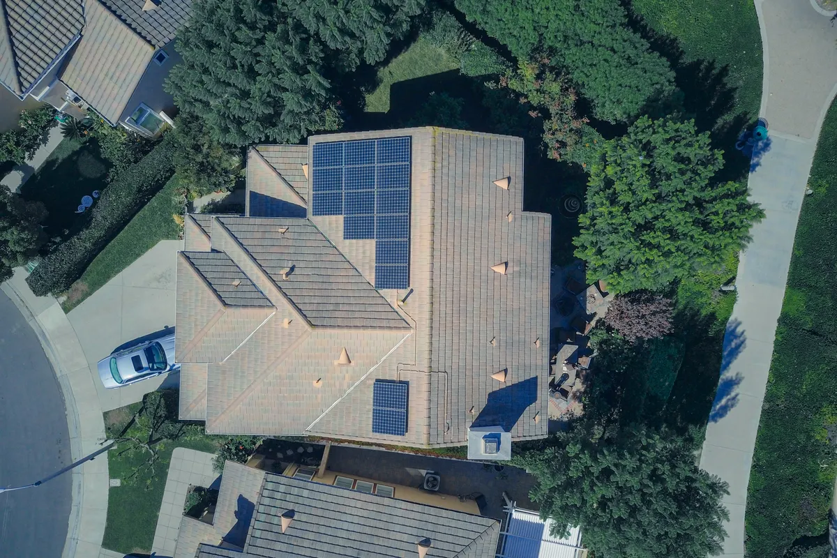 Vista cenital aérea de una casa con placas solares en el tejado