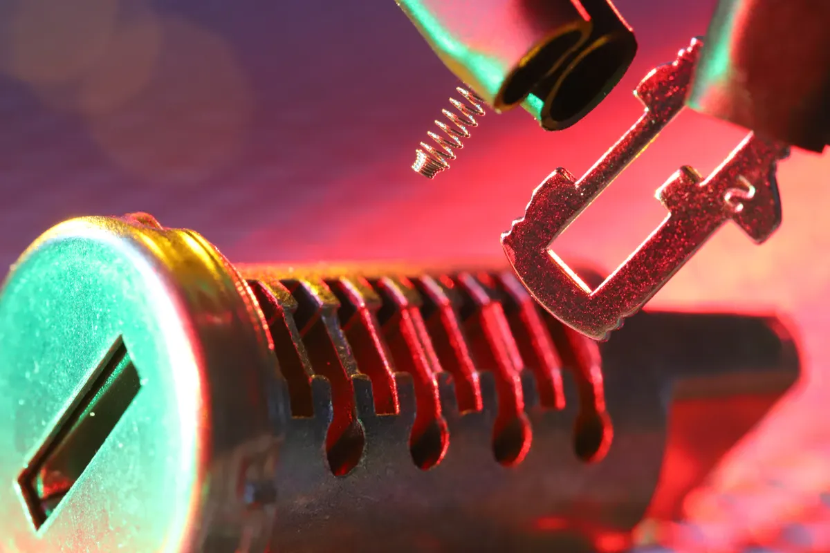 Vista macro de un bombín de cerradura y su llave con iluminación intensa